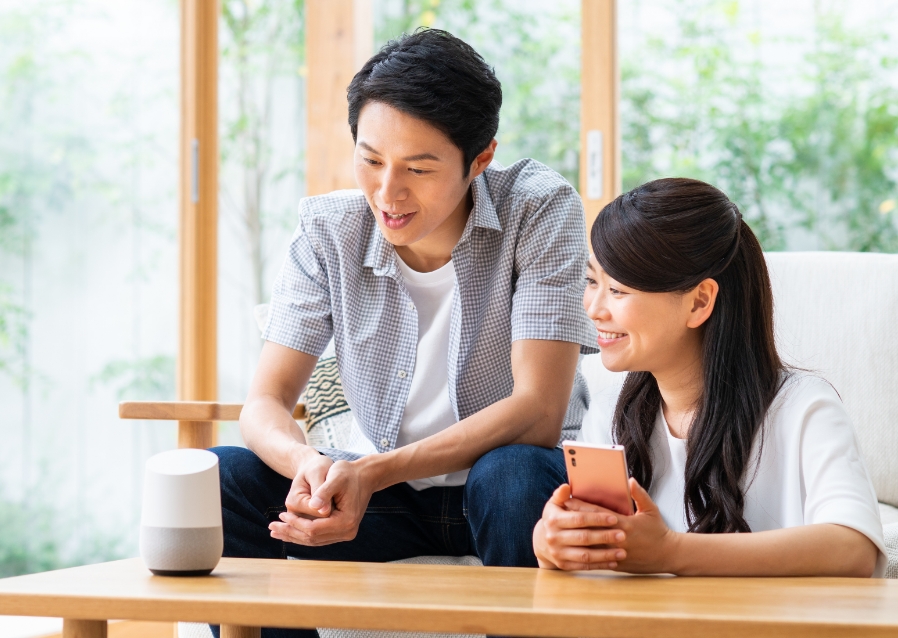 女性がスマートスピーカーと料理をしている写真