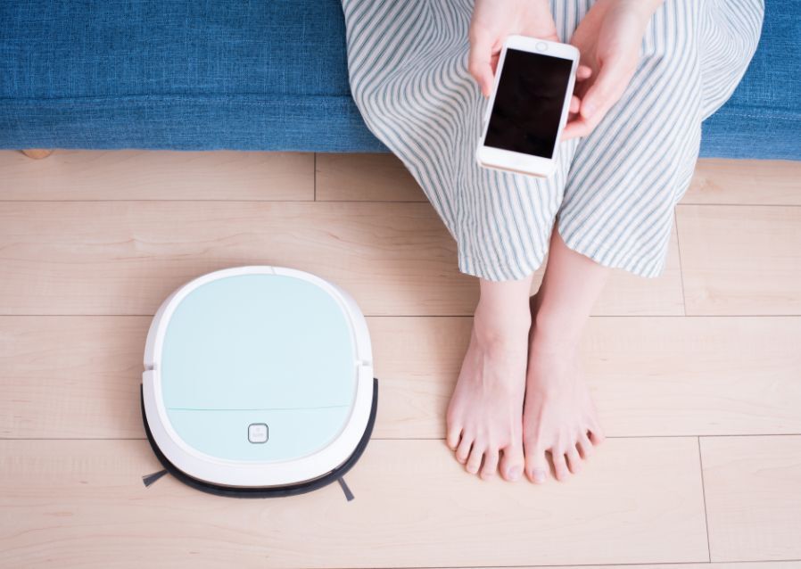 女性とロボット掃除機の写真